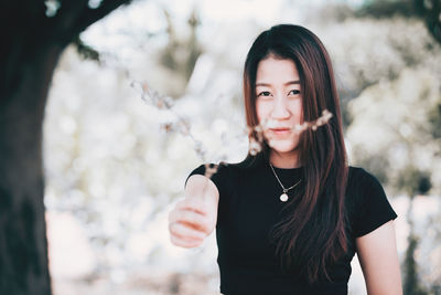 Portrait of beautiful young woman standing outdoors