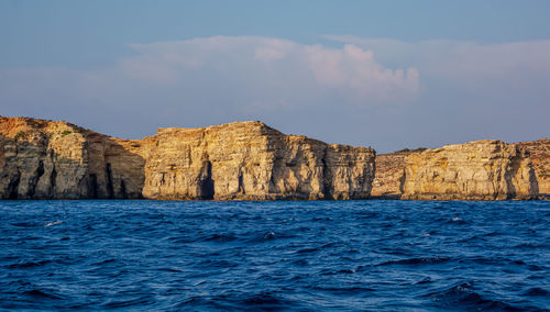 Scenic view of sea and rock formation against sky