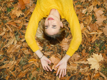 High angle view of woman lying down on autumn leaves