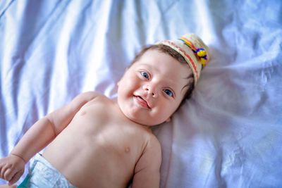 Portrait of cute baby boy lying on bed