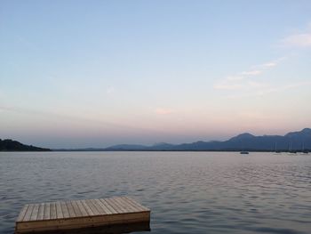 Diving platform in lake against sky at dusk