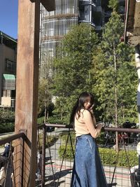 Portrait of young woman sitting on railing