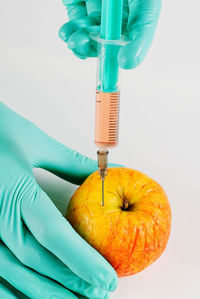 Midsection of doctor holding syringe against white background