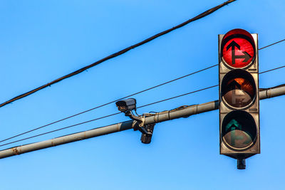 Low angle view of road sign against clear blue sky