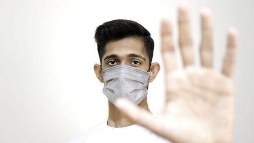 Portrait of man wearing mask against white background