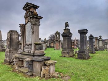 Various headstones in cemetery against sky