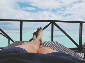 Man relaxing on lounge chair with seascape in background