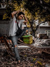 Full length of young man standing against tree