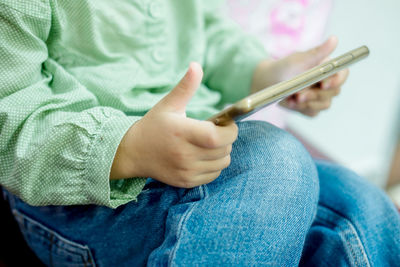 Midsection of man holding mobile phone