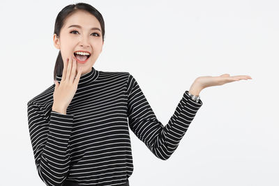 Portrait of smiling young woman against white background
