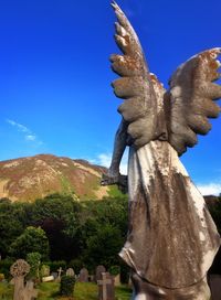 Low angle view of statue against blue sky