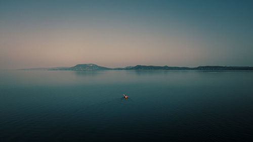 A lone paddler faces the north shore of lake balaton, the largest lake in central europe.