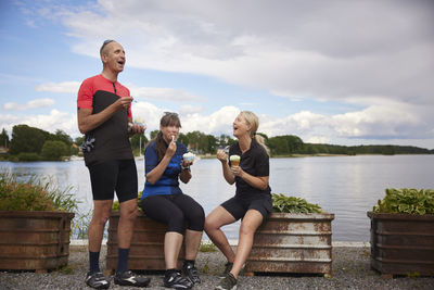 Happy friends having ice-cream at water