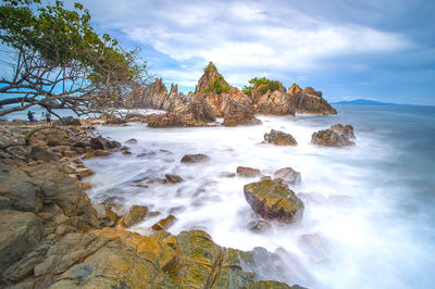 Scenic view of rocks in sea against sky