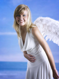 Portrait of beautiful young woman wearing angel wings