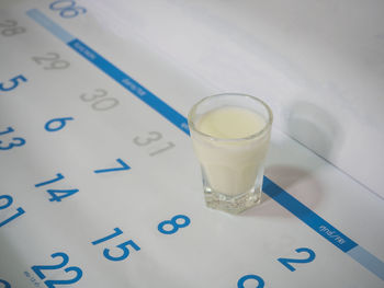 Close-up of glass of milk on calendar