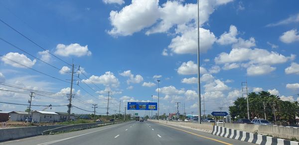 Vehicles on highway against sky in city