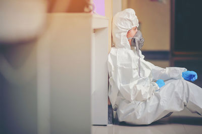 Rear view of woman working on white wall