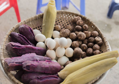 High angle view of eggs and vegetables in wicker basket