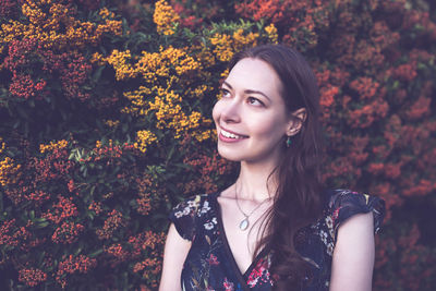 Beautiful brunette young woman in a garden, smiling. summer or fall season 
