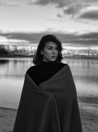 Portrait of woman standing near river on the beach