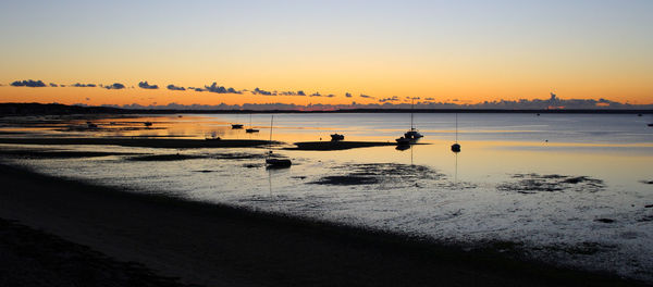 Scenic view of beach against sky during sunrise