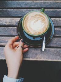 Close-up of cropped hand holding coffee cup