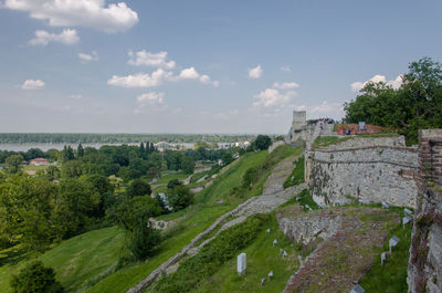 View of fortified wall and green landscape against sky