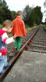 Two people sitting on railroad track