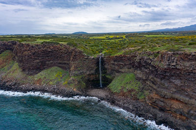 Scenic view of waterfall against sky