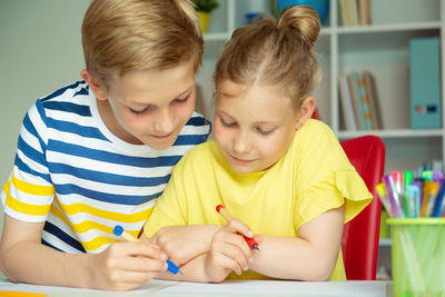 High angle portrait of boy with son on table