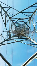 Low angle view of electricity pylon against clear blue sky