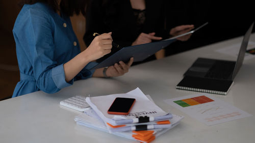 Midsection of woman using laptop on table