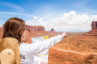 Rear view of woman standing against sky