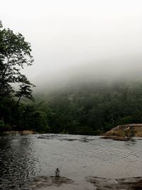 Scenic view of river by mountains against sky
