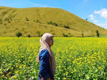 Side view of woman standing in field