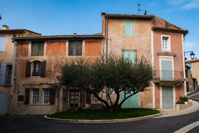 Residential building by street against sky