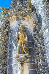 Low angle view of buddha statue against sky