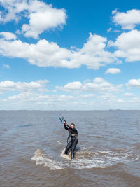 Young woman kitesurfing in beach