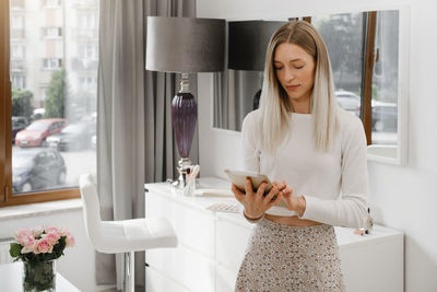 Woman working at reception in beauty salon. typing on tablet communicating with client, making