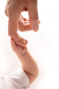 Cropped hand of baby on bed