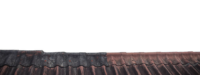 Low angle view of roof tiles against clear sky