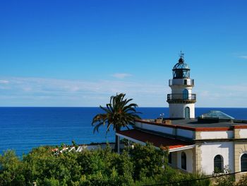 Building by sea against blue sky