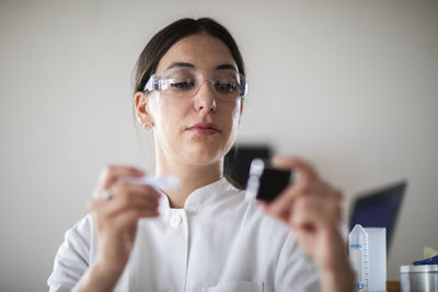 Scientist female with lab glasses, tablet and sample in a lab