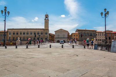 Group of people on street against buildings in city