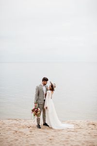 Bride and bridegroom standing at beach during wedding ceremony