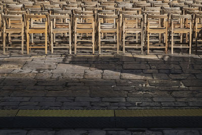 Full frame shot of empty chairs against brick wall