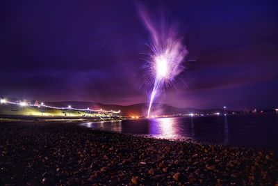 Firework display over sea at night