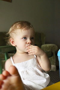 Close-up of baby girl lying on bed