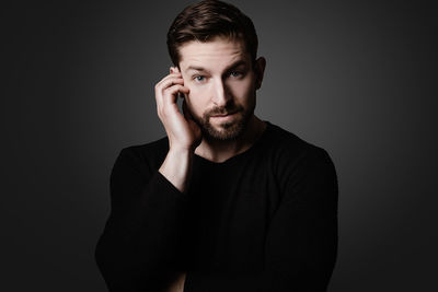 Young man wearing eyeglasses against black background